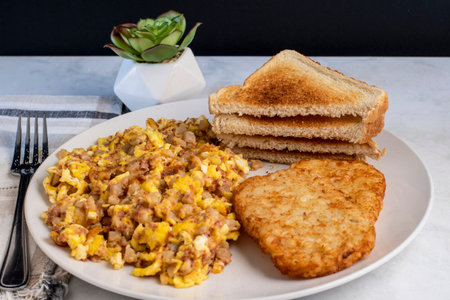scramble eggs mixed with corn beef hash and served with hash browns.の写真素材