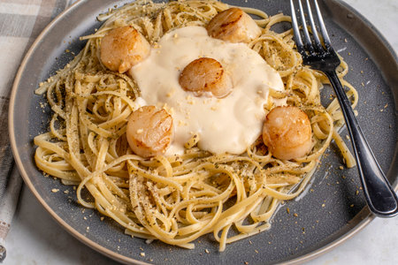 linguine with herbs and cheese served with  pan sheared scallops and alfredo sauce
