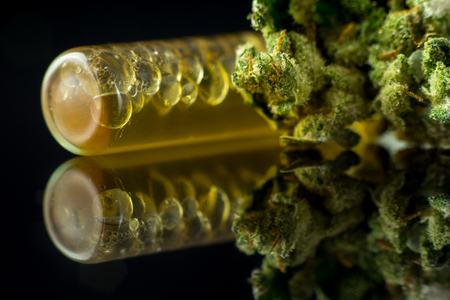 Medical Oil Cannabis - marijuana flower and oil cannabis on the mirror black background.の写真素材