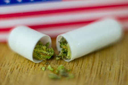 Medical Pills and tablets Cannabis - marijuana oil, resin and flowers with USA flag on fresh oak wood background.の写真素材