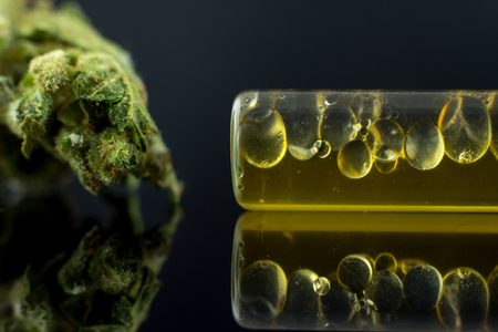 Medical Oil Cannabis - marijuana flower and oil cannabis on the mirror black background.の写真素材