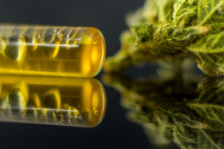 Medical Oil Cannabis - marijuana flower and oil cannabis on the mirror black background.の写真素材