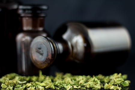 Medical Cannabis - view of marijuana in antique apothecary brown jar with dry marijuana on the black mirror background.の写真素材