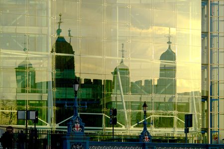 Tower of London refected in a modern building, gold evening sun.の写真素材