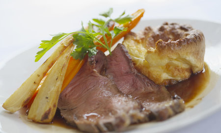 Roast beef with parsnits, carrots, Yorkshire pudding and gravyの写真素材