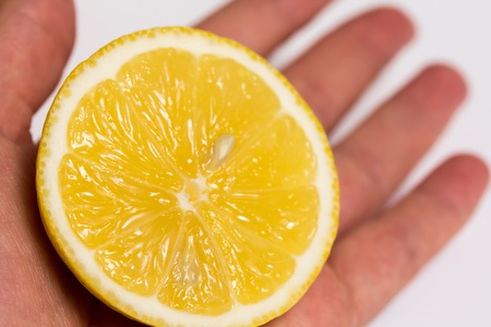 Half of a lemon in a woman open handの写真素材