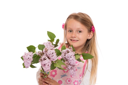 Happy little girl with long hair wearing summer dress and holding lilac flowers. Isolated on white background.の写真素材