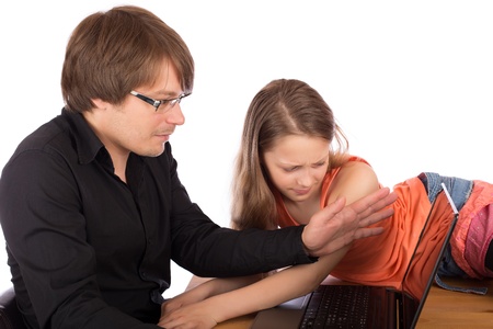 Father hides the screen of his laptop with his hand to his daughter who tries to watch what he do. Isolated on white background.の写真素材