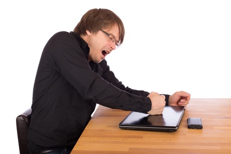 Angry man knock with his fist on his laptop. Isolated on a white background.の写真素材