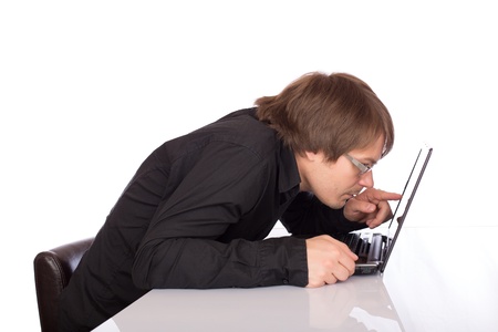 Sleepy business man look closely his laptop. Isolated on a white background.の写真素材