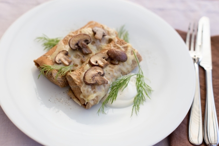 Tasty salty pancakes with mushrooms, cheese and sour cream.の写真素材