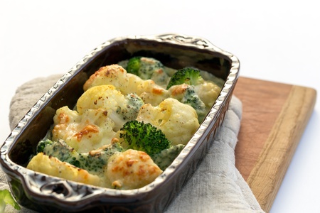 Gratin of cauliflower, broccoli and cheese in brown rustic dish.の写真素材