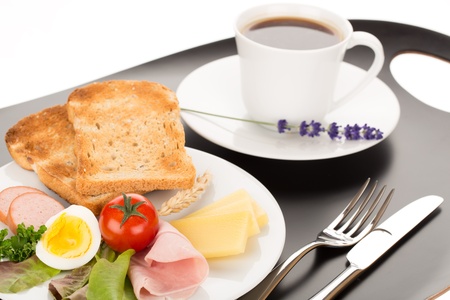 Breakfast with toast, cheese, sausage, ham, tomato, egg and cup of coffee.の写真素材