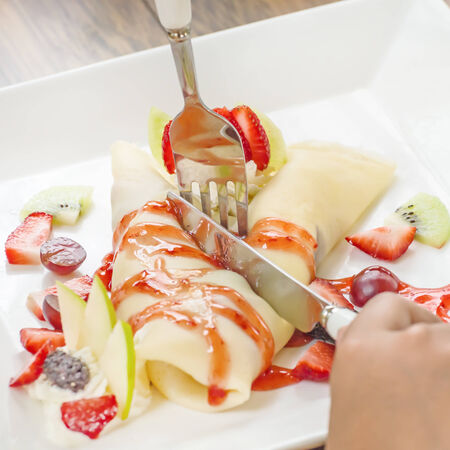 Sweet thin crepes folded with strawberries and creamの写真素材