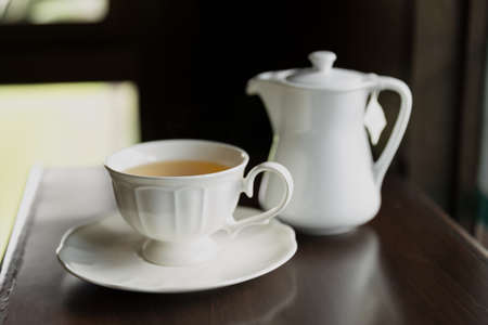 Cup of tea and teapot on wooden table closeupの写真素材