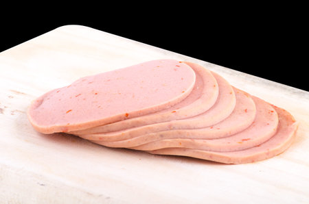 baloney sausage slices isolated on black backgroundの写真素材