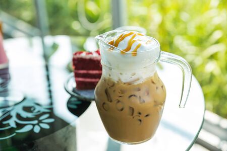 Iced coffee in jug, jar, mug glass cups on the tableの写真素材