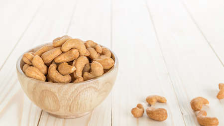 organic cashew with no shell on a background, roasted cashews on natural wooden table backgroundの写真素材