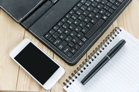 Office table with notebook, tablet keyboard and smartphoneの写真素材