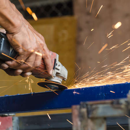 cutting steel rod by machine on a day at the construction site, Electric wheel grinding on steel structure in factoryの写真素材