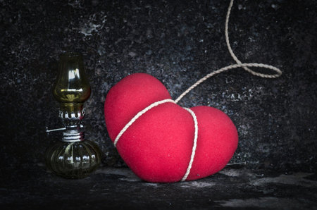 Still life with red heart and old lamp in grunge background-Sad conceptの写真素材