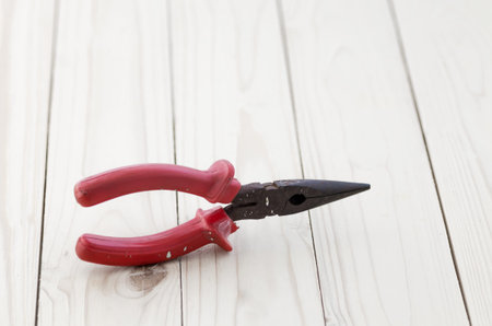 Pliers tools for electrician on wooden background, A pair of rusty needle nosed pliersの写真素材