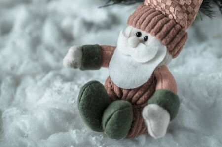 doll of santa claus sitting in the snow,santa claus sitting on snow in vintage backgroundの写真素材