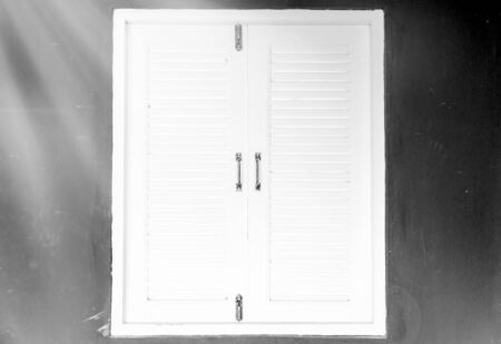 window with white shutters on wall - black and whiteの写真素材