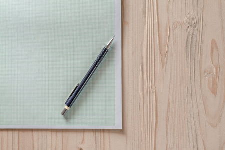 Drafting paper or graph paper with pencil on wooden desk,close up blank graph paper on wooden desk...