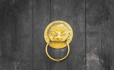 golden lion head on old chinese traditional doorの写真素材