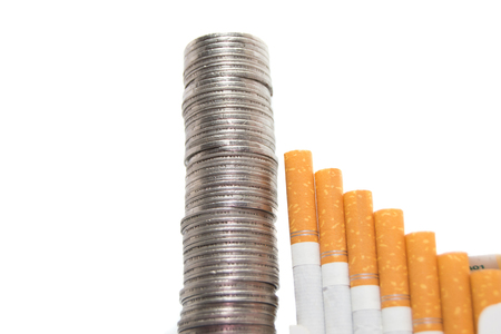 Rising expenses concept of cigarettes and coins isolated on whiteの写真素材