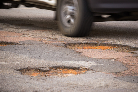 Moving car close to drive into a big potholeの写真素材