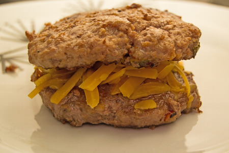 Beef patties on top with cheese in centerの写真素材