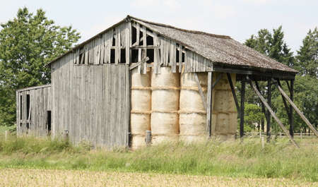 Old wooden barn with bales of hayの写真素材