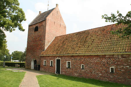 Ezinge. August-16-2020. The tower of the Church of Ezinge and historic house in the village Ezinge. the Netherlandsのeditorial素材