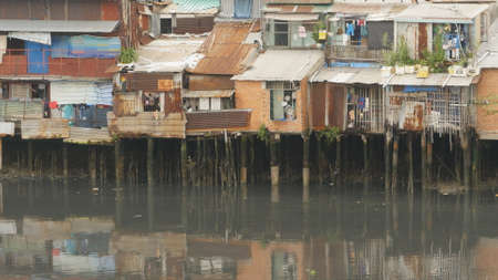 Views of the city's Slums from the river (in the background and in reflection of the new buildings) Ho Chi Minh City (Saigon), Vietnam.の写真素材