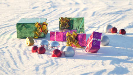 Christmas gifts in a field on snow in a sunny, frosty and clear weather outdoors.の写真素材