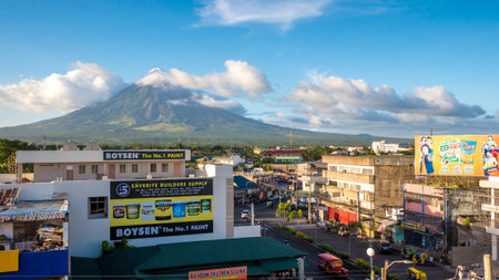 LEGAZPI, PHILIPPINES - JANUARY 5, 2018: - Mount Mayon volcano looms over the city as daily life goes...