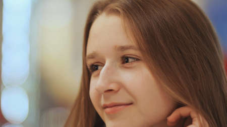Close-up face of young beautiful schoolgirl, drinking coffee from a cup.の写真素材