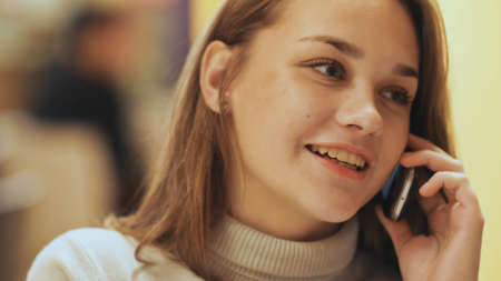 Cute young girl talking on a cell phone. Close-up.の写真素材