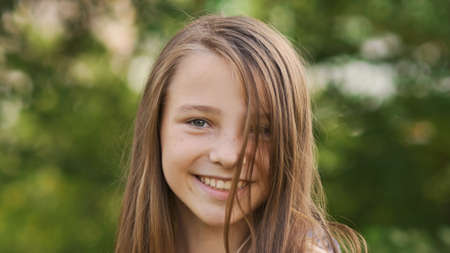 Girl teenager face close-up with freckles and funny posing embarrassed and playing with his hair.の写真素材