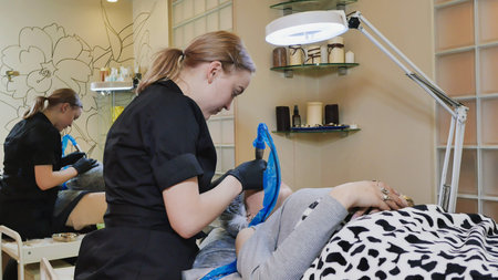 Permanent makeup. Permanent tattooing of eyebrows. Cosmetologist applying permanent make up on...