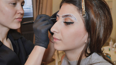 Permanent makeup. Permanent tattooing of eyebrows. Cosmetologist applying permanent make up on...