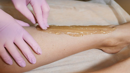 Depilation of legs with sugar paste or Shugaring. Beauty saloon.の写真素材