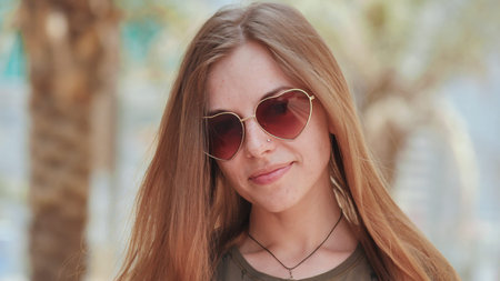 Girl in sunglasses on the background of Dubai streets and palms trees. Face close-up.