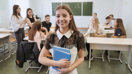 Portrait of a young Russian senior school graduate showing success with the help of a finger in the up.の写真素材