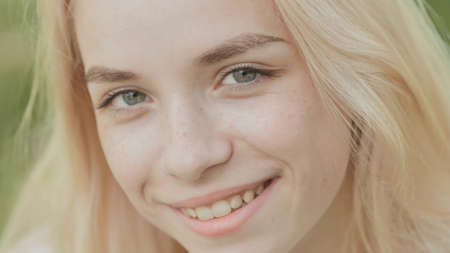 Close-up face of a smiling 19 year old blonde girl.の写真素材