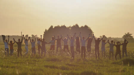 Friends of schoolchildren are bouncing at sunset in the sun.の写真素材
