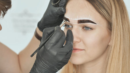 Create permanent eyebrow makeup. Eyebrow dyeing. Face close-up.