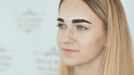 Create permanent eyebrow makeup. Marking the shape of the eyebrows.